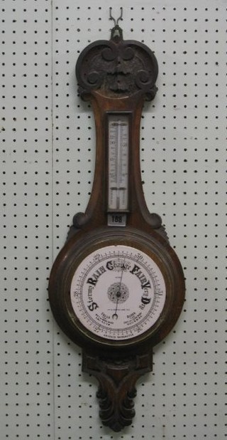 A 19th Century aneroid barometer and thermometer with 6 1/2" circular enamelled dial by Monk 177-179 Rye Lane SE, contained in a carved oak wheel case (bezel f)