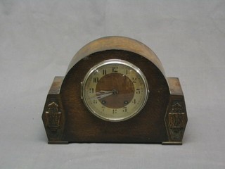 A 1930's 8 day striking mantel clock contained in an oak arched case by Brevingtons