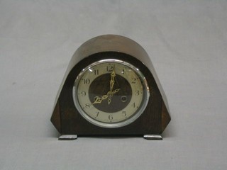 A 1930's 8 day striking mantel clock with Arabic numerals contained in an oak arched case