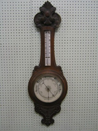 A 19th Century aneroid barometer and thermometer with porcelain dial contained in a carved oak wheel case