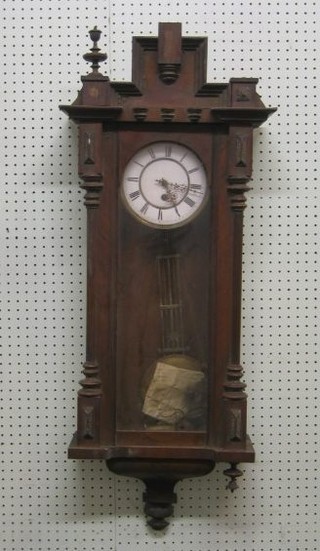 A Vienna style wall clock with 6 1/2" porcelain dial and grid iron pendulum contained in a walnutwood case