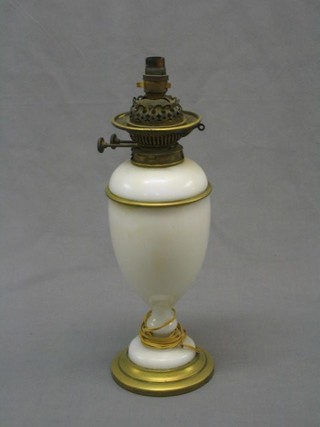An opaque glass oil lamp with reservoir and gilt metal mounts (crack to the side) converted to electric table lamp