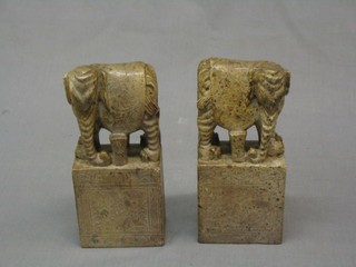 A pair of carved soap stone book ends decorated elephants 8"