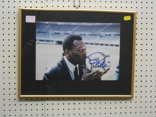 A signed colour photograph of Pele kissing a football, dated '93 8" x 11 1/2"