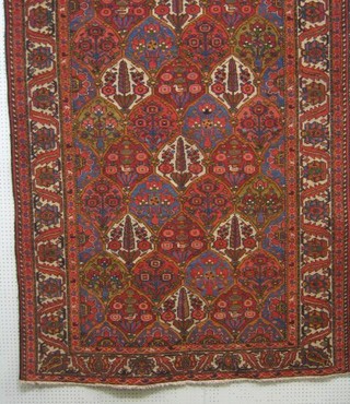 A contemporary red ground and floral patterned Persian carpet, 116" x 64"