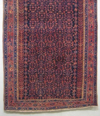 A contemporary blue and red floral patterned Persian rug within multi row borders 121" x 58"