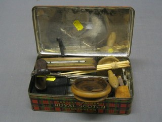 A Huntley & Palmer Royal Scots shortbread biscuit tin containing a book of Common Prayer, 2 boot hooks, 2 carved wooden figures and other curios