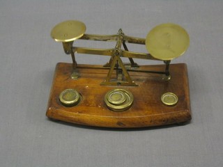 A pair of 19th Century brass letter scales raised on an oak base