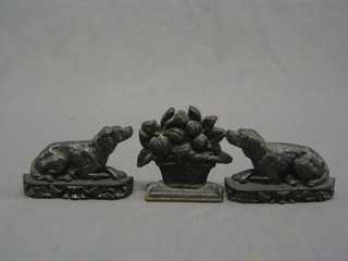 A pair of cast iron miniature door stops in the form of dogs  6" and 1 other in the form of a basket of fruit 4"