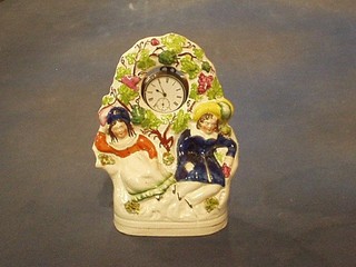A 19th Century Staffordshire pocket watch holder in the form of 2 figures, complete with silver open faced pocket watch 8"