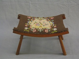 A mahogany saddle seat stool with Berlin wool work upholstered seat, on octagonal supports 24"