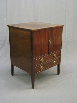 A Georgian mahogany commode enclosed by a panelled door, the base fitted a drawer raised on square tapering supports 24"