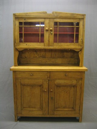 A 19th Century Continental stripped and polished pine dresser with raised back, the base fitted 2 drawers above a double cupboard 46"