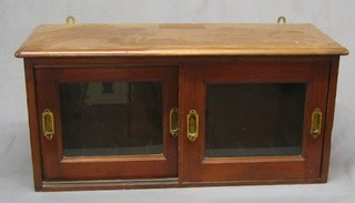 A 19th Century mahogany hanging cabinet enclosed by glazed sliding doors with brass counter sunk handles, marked LNWR, 32" 