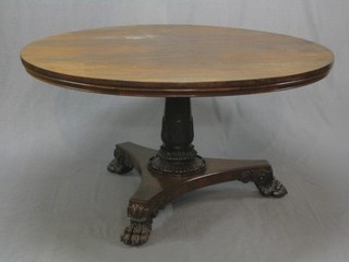 A William IV circular rosewood snap top breakfast table raised on a turned column with triform base and paw feet, 53"