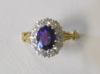A lady's gold dress ring set an oval cut amethyst surrounded by numerous diamonds