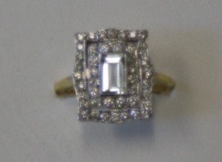 A lady's gold dress ring set a rectangular cut aquamarine surrounded by 2 rows of diamonds