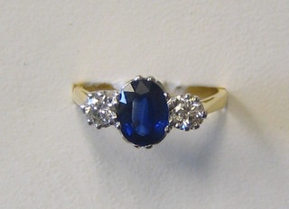 A lady's gold dress/engagement ring set an oval cut sapphire and 2 diamonds