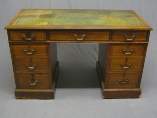 An Edwardian walnut kneehole pedestal desk with inset tooled leather writing surface, above 9 drawers 49"