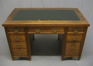 A Victorian walnut kneehole pedestal desk with inset tooled writing surface above 9 drawers 48"
