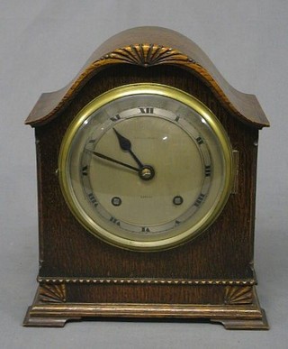 A 1930's 8 day bracket clock with silvered dial and Roman numerals contained in an arch shaped case by Kendal & Dent