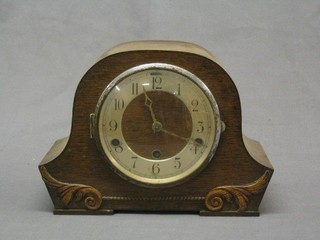 A 1930's 8 day striking mantel clock with Arabic numerals in an oak arched case