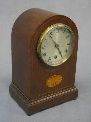 An Edwardian 8 day mantel clock with silvered dial and Roman numerals contained in an arched inlaid mahogany case