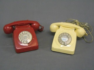 A red plastic dial telephone  and a white plastic dial telephone