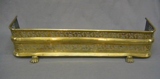 A 19th Century pierced brass fender on paw supports 36"