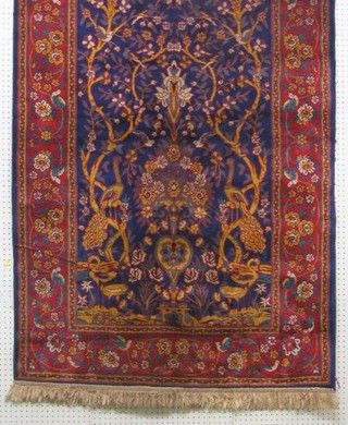 A blue ground Belgian cotton Persian style carpet decorated a garden with trees within multi-row borders, 70" x 46", the reverse labelled Sarook-Kashan Silk