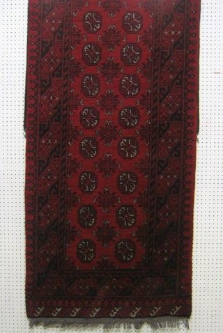A contemporary Afghan runner with 32 octagons within multi row borders 112" x 31"