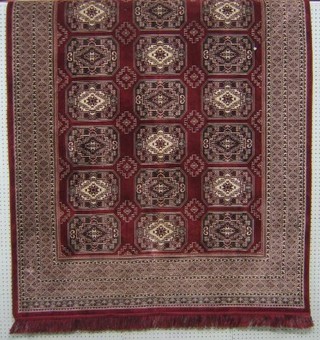 A red ground Persian style machine made rug 81" x 55"