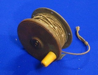 A 19th Century brass centre pin fishing reel by the Army & Navy Co-operative Society Ltd 105 Victoria Street Westminster (f) together with a pierced metal centre pin reel (2)