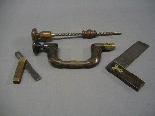 A 19th Century brass and turned wooden brace, a wooden and polished steel centre drill and 2 squares