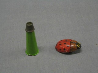 A tin plate figure of a ladybird 2" and a tin plate duck call 3" (2)