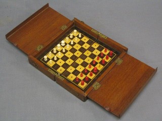 A 19th/20th Century mahogany cased travelling chess set with white and red carved ivory pieces (red king f)