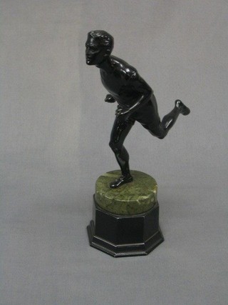 An Art Deco black painted metal figure of a runner, raised on a marble base 10"
