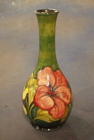 A Moorcroft Hibiscus pattern green glazed club shaped vase, the base with impressed Moorcroft and signature mark and with paper label Potter To The Late Queen Mary, (mouth f and r), 11"