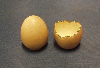 A McIntyre 2 piece condiment set, the pepper in the form of a egg shell and the salt in the form of a hatched shell, the base impressed McIntyre RD No. 10587 and 10586