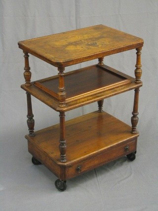 A Victorian figured walnut 3 tier what-not the base fitted a drawer, incorporating a later tray and raised on castors, 22"