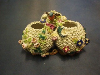 A reproduction 19th Century vase in the form of a 3 globular bowls with with floral encrusted decoration surmounted by a bird 8"