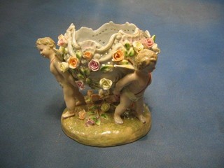 A Dresden style porcelain table centre piece supported by cherubs 7"