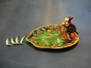 A reproduction Majolica style hors d'eouvres dish, the handle in the form of a squirrel 10" and 4 pottery fish knife rest 3"