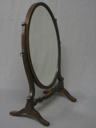A Sheraton style oval plate dressing table mirror contained in an inlaid mahogany swing frame