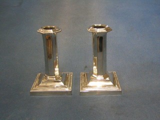 A pair of good quality 19th Century silver plated candlesticks with detachable sconces, chamfered columns and bead decoration, raised on square feet 5"