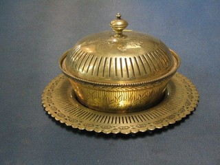An Edwardian circular engraved silver plated butter dish, raised on a circular pierced stand with glass liner and domed lid 9"