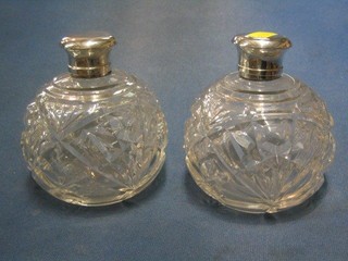 A pair of cut glass globular shaped perfume bottles with silver plated lids 5"