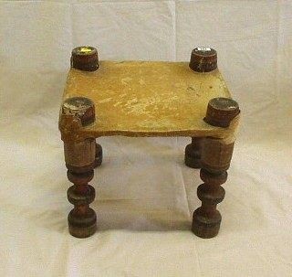 An Eastern stool on turned supports with hide seat 15"