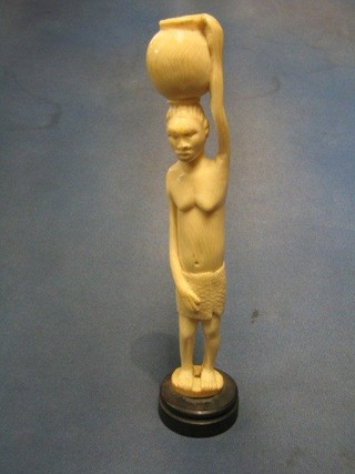 A carved ivory figure of  a standing native lady 10", raised on a socle base