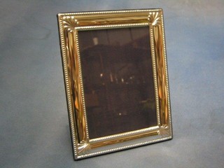 A modern silver easel photograph frame with bead work border 6 1/2" x 5"